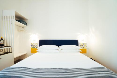 a white bedroom with a blue and white bed at Suite Lia - Private Room with garden and tub close to Villa Eva e Cimbrone, Ravello in Ravello