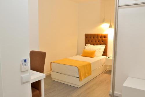 a small bedroom with a bed and a mirror at Hotel Sol Algarve by Kavia in Faro