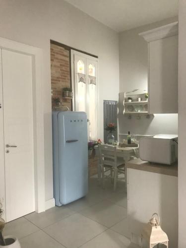 eine Küche mit einem weißen Kühlschrank und einem Tisch in der Unterkunft Enry White House in Cagliari