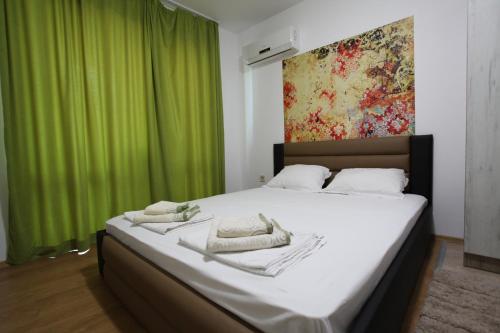een slaapkamer met een groot bed en een groen gordijn bij Villa Salena in Primorsko