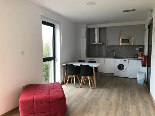 a kitchen with a table and chairs in a room at Apartamentos Compostela in Lobios