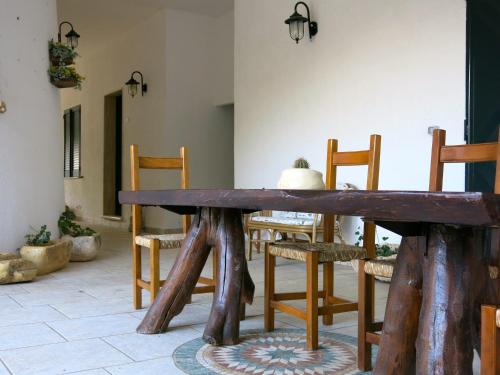 uma sala de jantar com uma mesa de madeira e cadeiras em Agriturismo Tenuta Del Morige em Galatone