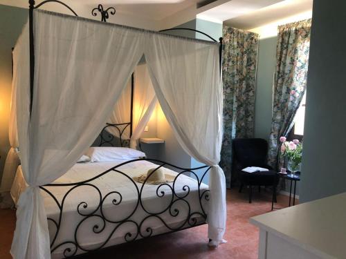 a bedroom with a black canopy bed with curtains at Locanda dei Sette Limoni - camere e residence in Vada