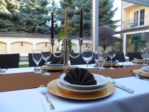 a table with wine glasses and plates on it at Xavin Wellness Hotel & Restaurant in Harkány