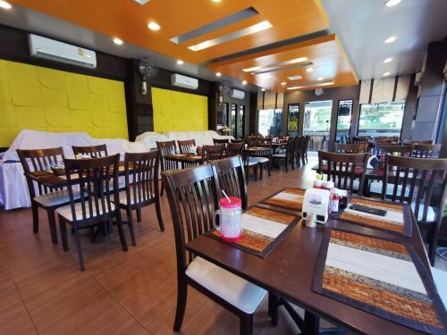 a restaurant with tables, chairs, and tables in it at The Great Residence Hotel in Lat Krabang