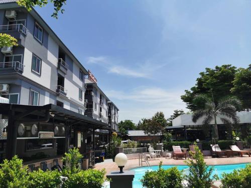 a hotel with a swimming pool next to a building at The Great Residence Suvarnabhumi Airport in Lat Krabang