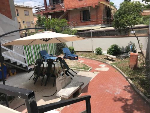 a patio with a table and chairs and an umbrella at Villa belvedere in Pontecagnano