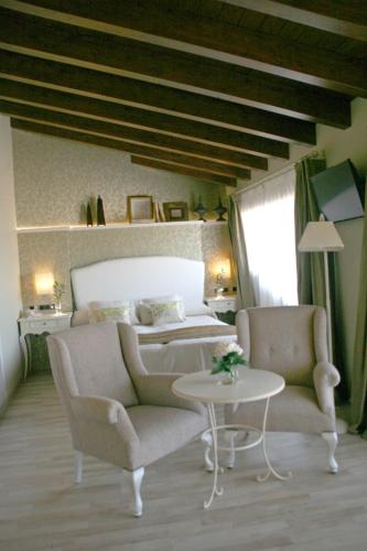 a bedroom with a bed and two chairs and a table at Hotel Castillo de Alquézar in Alquézar