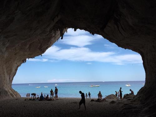 a group of people on a beach with the ocean at CAV Mameli in Dorgali
