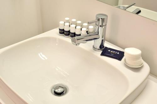 a bathroom sink with a faucet and some bottles on it at Hotel Sol Algarve by Kavia in Faro