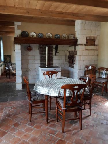 une salle à manger avec une table et des chaises et une cheminée dans l'établissement Au Colombier des Arteaux, à Licques