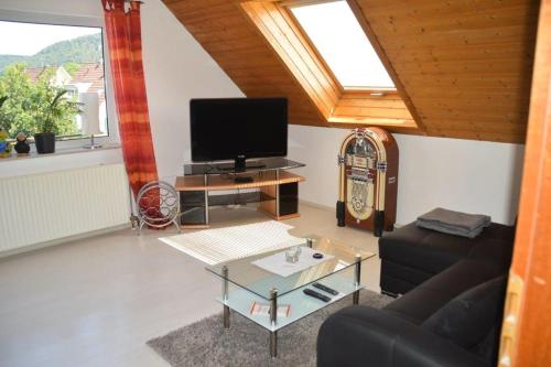 uma sala de estar com um sofá e uma televisão em Ferienwohnung Sonnenblick em Albstadt