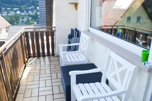 a balcony with two white chairs and a window at Ferienwohnung Sonnenblick in Albstadt