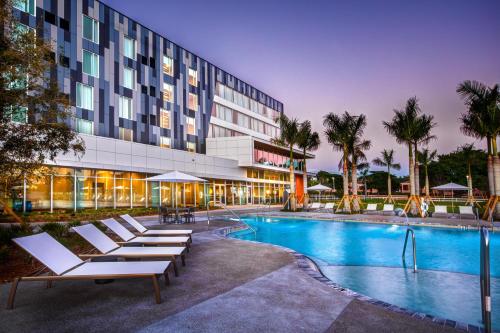 um hotel com piscina e espreguiçadeiras em Legacy Hotel at IMG Academy em Bradenton