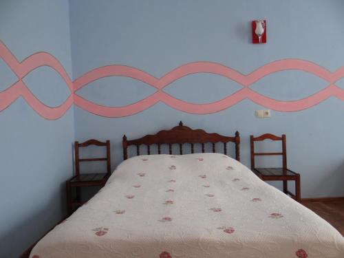a bedroom with a bed with a pink headboard at Dalko in Borjomi
