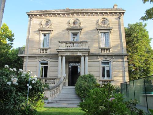 une vieille maison avec des escaliers en face de celle-ci dans l'établissement La Maison de Sophie, à Nîmes