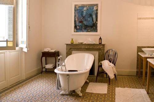 a bathroom with a bath tub and a fireplace at La Maison de Sophie in Nîmes