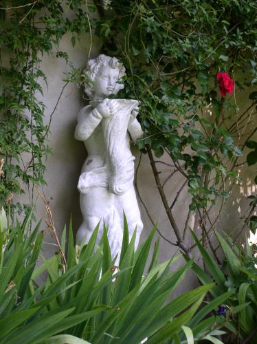 a white statue of a cherub holding a rose at La Maison de Sophie in Nîmes