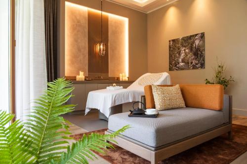 a living room with a couch and a table at Althoff Seehotel Überfahrt in Rottach-Egern