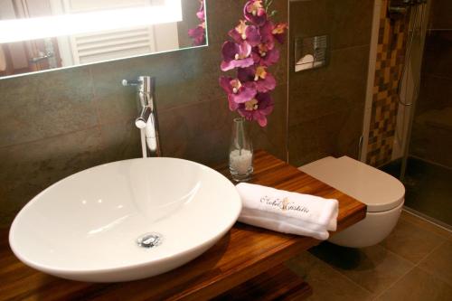 a bathroom with a sink and a toilet and flowers at Hotel Castillo de Alquézar in Alquézar