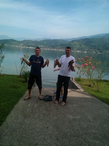 two men standing on a path near a body of water at Dina apartman Jablaničko jezero in Konjic