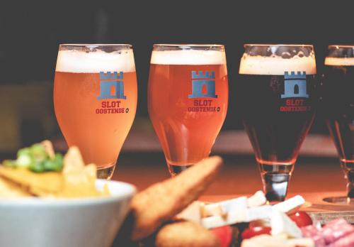 three glasses of beer on a table with food at Slot Oostende in Goes