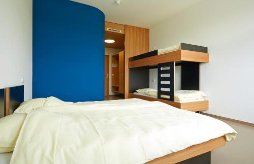 1 dormitorio con cama y pared azul en Youth Hostel Beaufort, en Beaufort