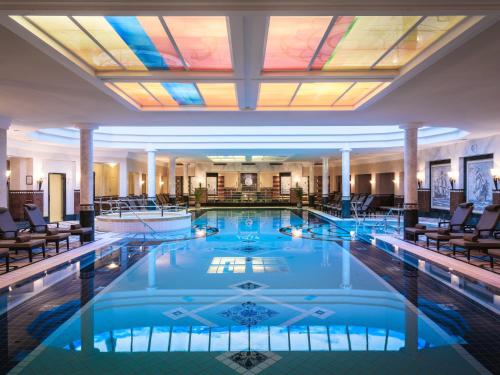 a pool in a hotel lobby with a skylight at Althoff Seehotel Überfahrt in Rottach-Egern