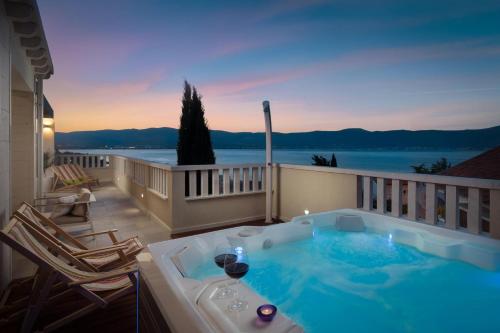 een hot tub op een balkon met uitzicht op het water bij Secret Escape Penthouse in Slatine