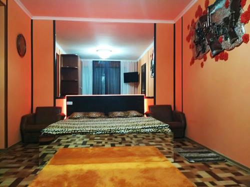 a bedroom with a bed with orange walls at Студия in Kryvyi Rih