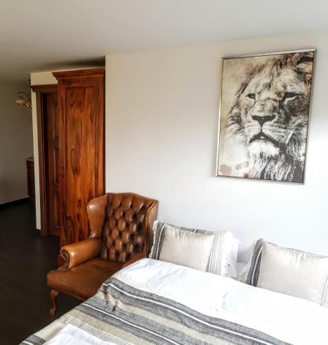 a bedroom with a bed and a chair and a painting at Villa Watamu in Trzęsacz