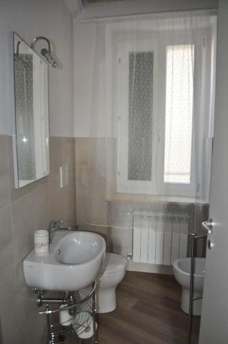 a white bathroom with a sink and a toilet at La Torre in Vasto