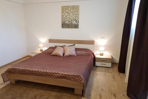 - une chambre avec un lit, 2 tables de nuit et 2 lampes dans l'établissement APARTMENT NORINA, à Grožnjan