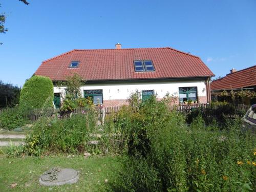 a white house with a red roof at Ruegen_Fewo 43 in Grahlhof