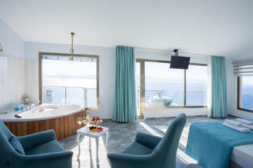 a bathroom with a tub and a bed and a tub and a sink at Fener Hotel Café & Kahvalti in Çeşme