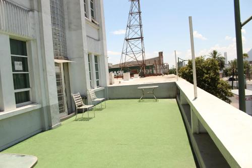 a balcony with chairs and a table on a building at Hotel Plaza del Arco Express in Monterrey