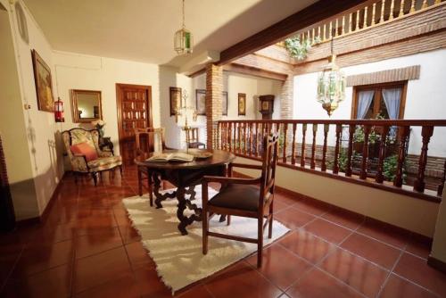 a dining room with a table and a balcony at Palacete Magistral Domínguez habitaciones in Guadix