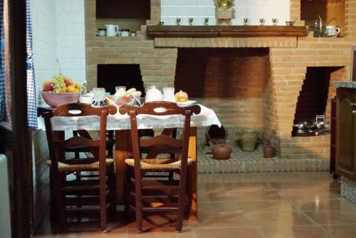 a table in a kitchen with a fireplace at Palacete Magistral Domínguez habitaciones in Guadix