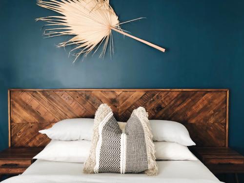 a bedroom with a blue wall and a bed with pillows at 27 Degrees Kalbarri in Kalbarri
