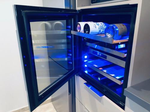 an empty refrigerator with blue lights in it at Gîte Wellness Le Six H in Andolsheim