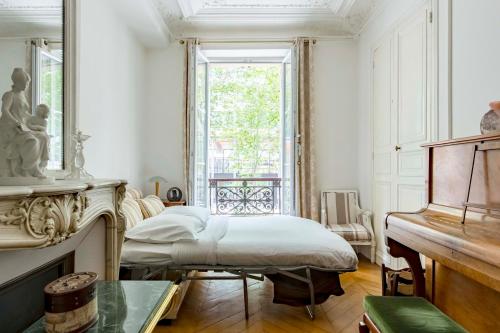 une chambre avec un lit et une fenêtre dans l'établissement Veeve - By Boulevard Saint Germain, à Paris