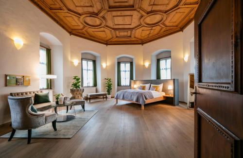 Großes Zimmer mit einem Bett und einem Sofa in der Unterkunft JUFA Hotel Schloss Röthelstein in Admont