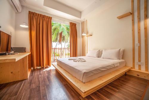 a bedroom with a bed and a large window at Portia Hotel & Spa in Dhiffushi