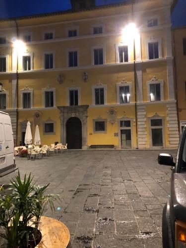 a large yellow building with tables and chairs in a courtyard at "CASA ROSI" Tel trequattrozero trentatre tredici seiquattrouno in Umbertide