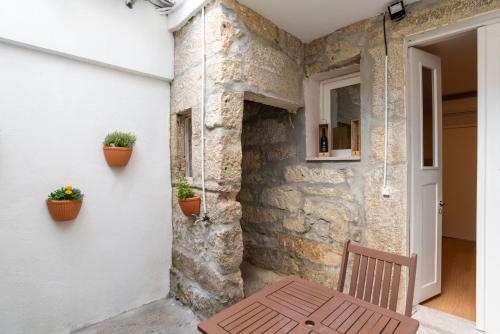 a wooden bench sitting next to a wall with plants at ZD Moreira Flats A By PortoProperties4You in Porto