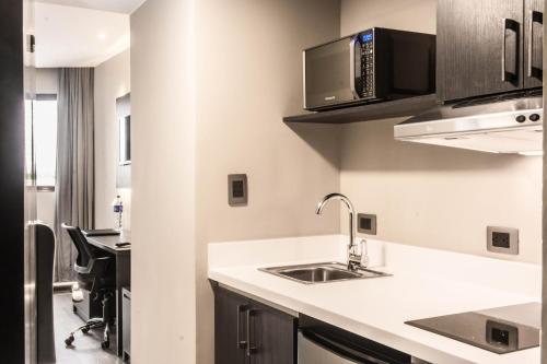 a kitchen with a sink and a microwave at W&P Santo Domingo in Santo Domingo