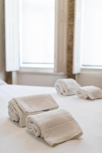 a group of towels sitting on a bed at ZD Moreira Flats A By PortoProperties4You in Porto
