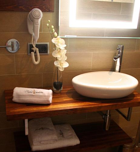 a bathroom counter with a sink and a vase of flowers at Hotel Castillo de Alquézar in Alquézar