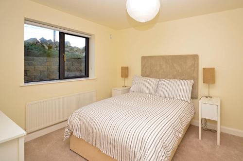 a bedroom with a bed with two night stands and a window at Property 260 - Moyard in Moyard