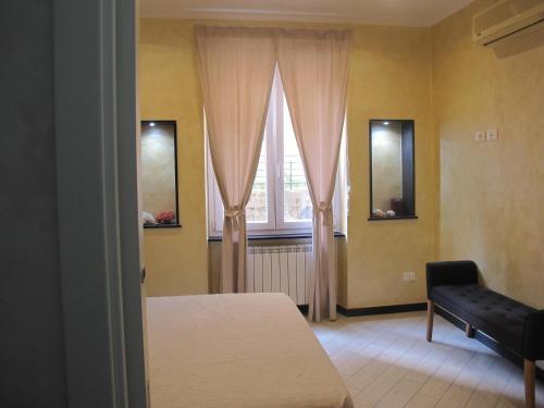 1 dormitorio con cama, ventana y silla en LA GEMMA en Génova